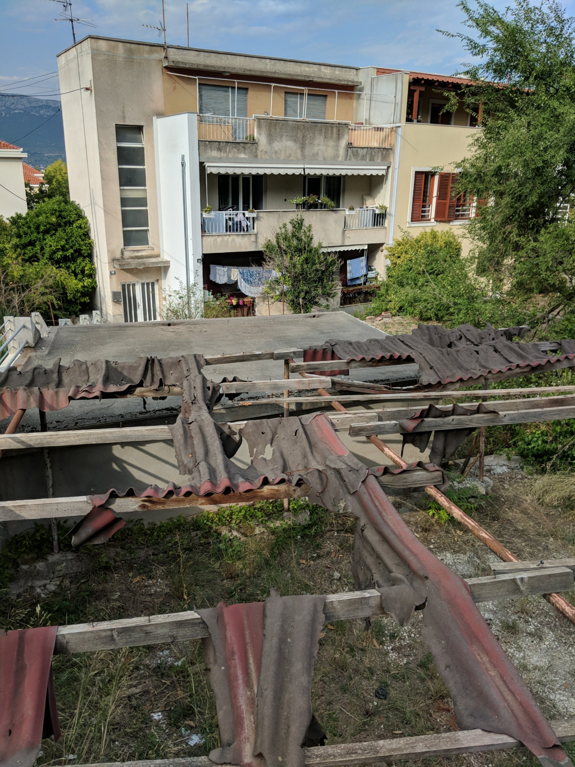 A shed in disrepair and a concrete apartment building in Split, Croatia