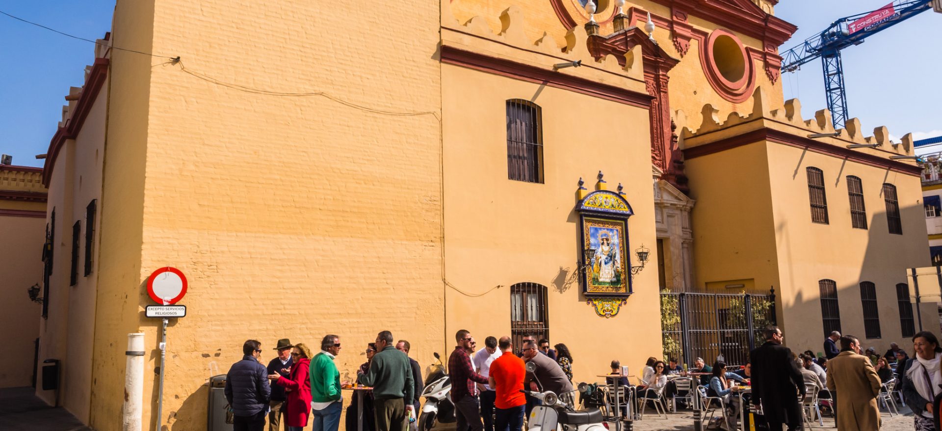 Patrons from Bar Bistec Gather in the plaza at Triana's Iglesia de Santa Ana